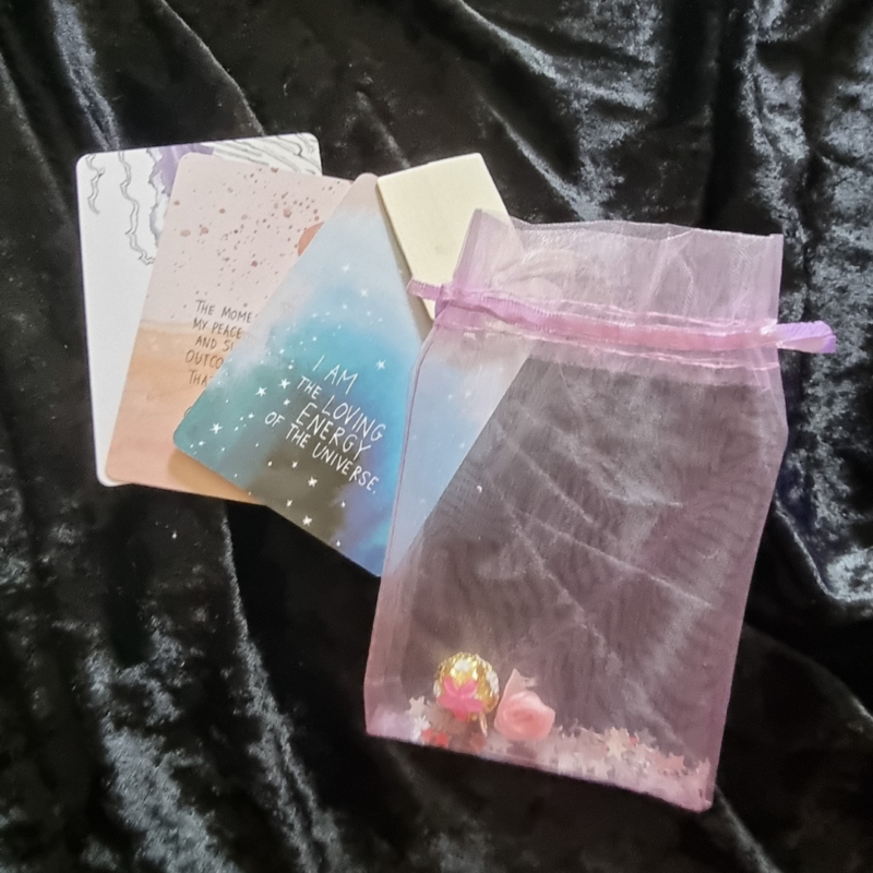 A pink Little Bags of Positivity - Lilac pouch with a card and a note.