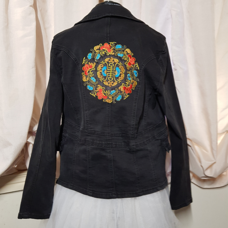 A Chinese Mandala Upcycled Denim Jacket with floral mandala designs.