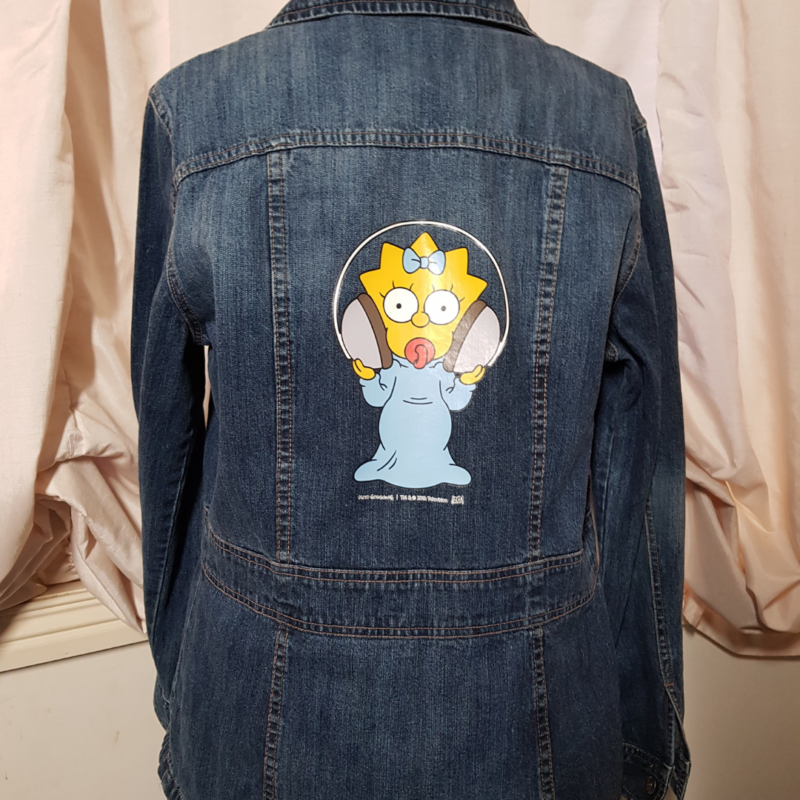 An Maggie Simpson Upcycled Denim Jacket featuring an image of Maggie Simpson.